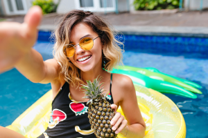 winsome-girl-in-yellow-sunglasses-holding-pineapple-and-laughing-gorgeous-LEVE